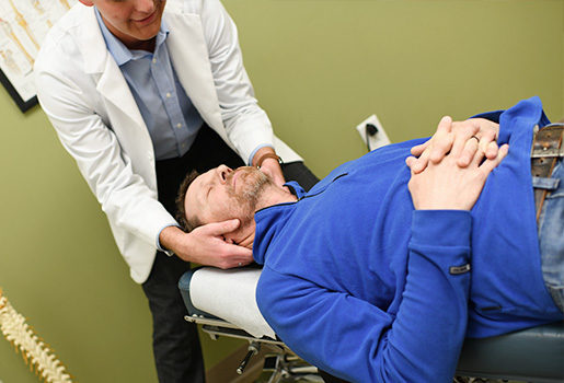 Chiropractor adjusting patient.